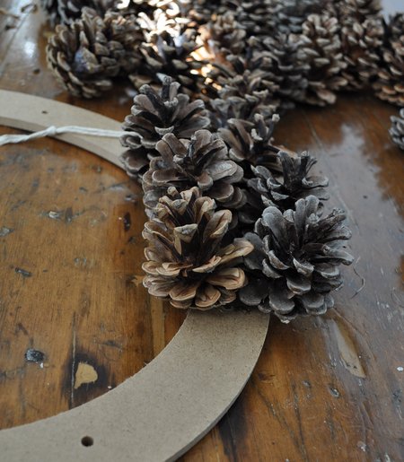 pine cones glued to a wood wreath form