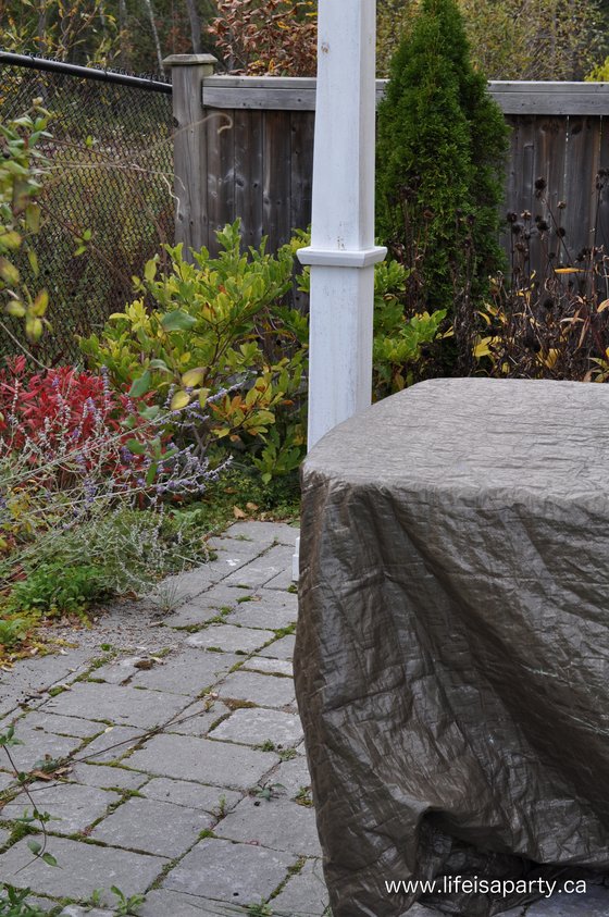 covering up garden furniture with tarps to protect them in the winter