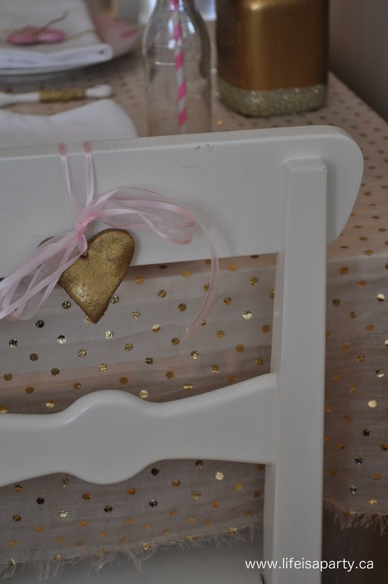 valentines day table gold and pink with salt dough hearts tied onto the backs of the chairs