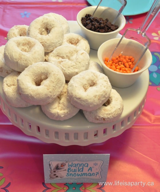 Wanna Build a Snowman donuts with chocolate chips and orange candies to build your own Olaf