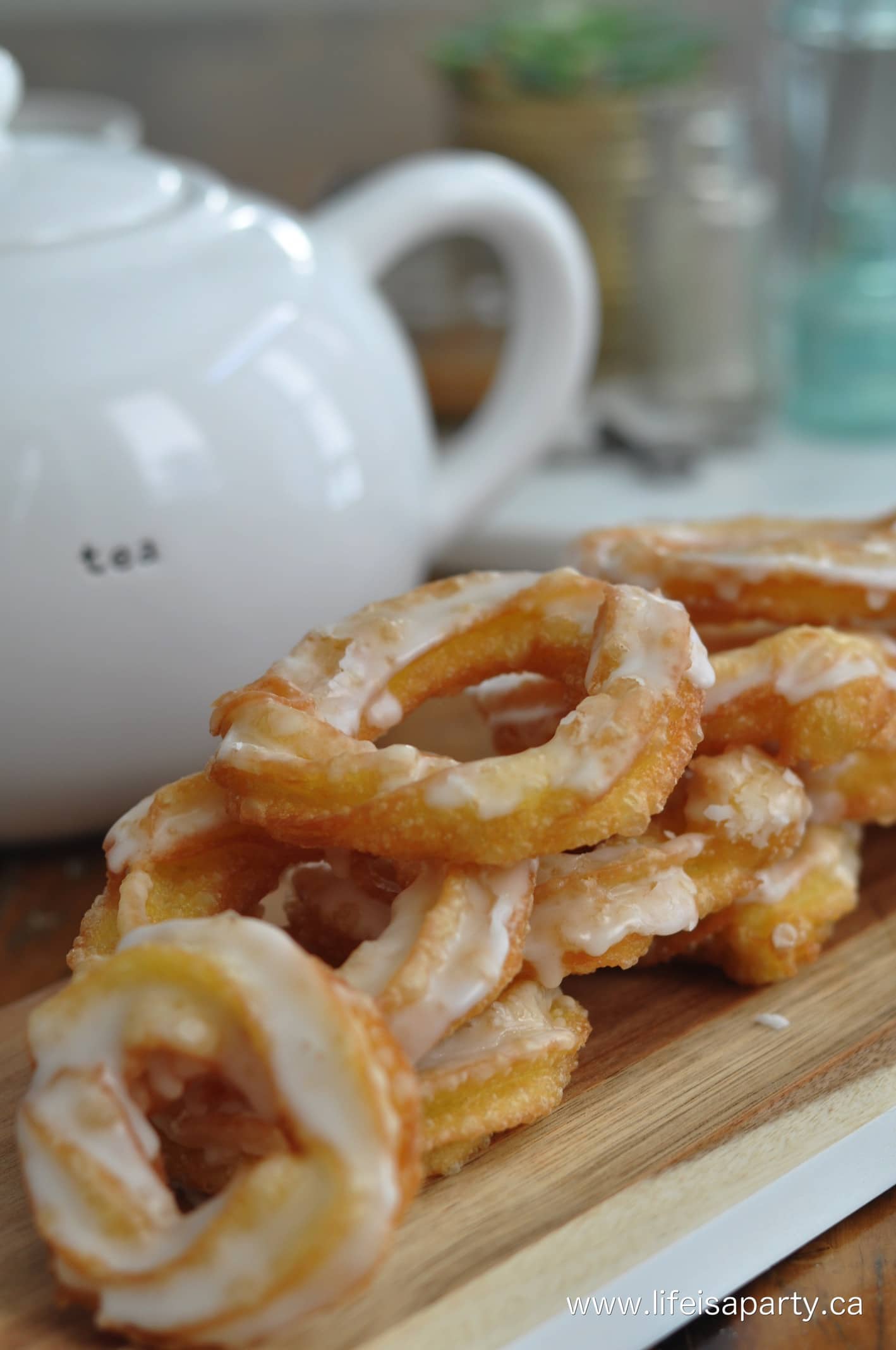 Homemade Honey Cruller Donuts stacked beside a teapot