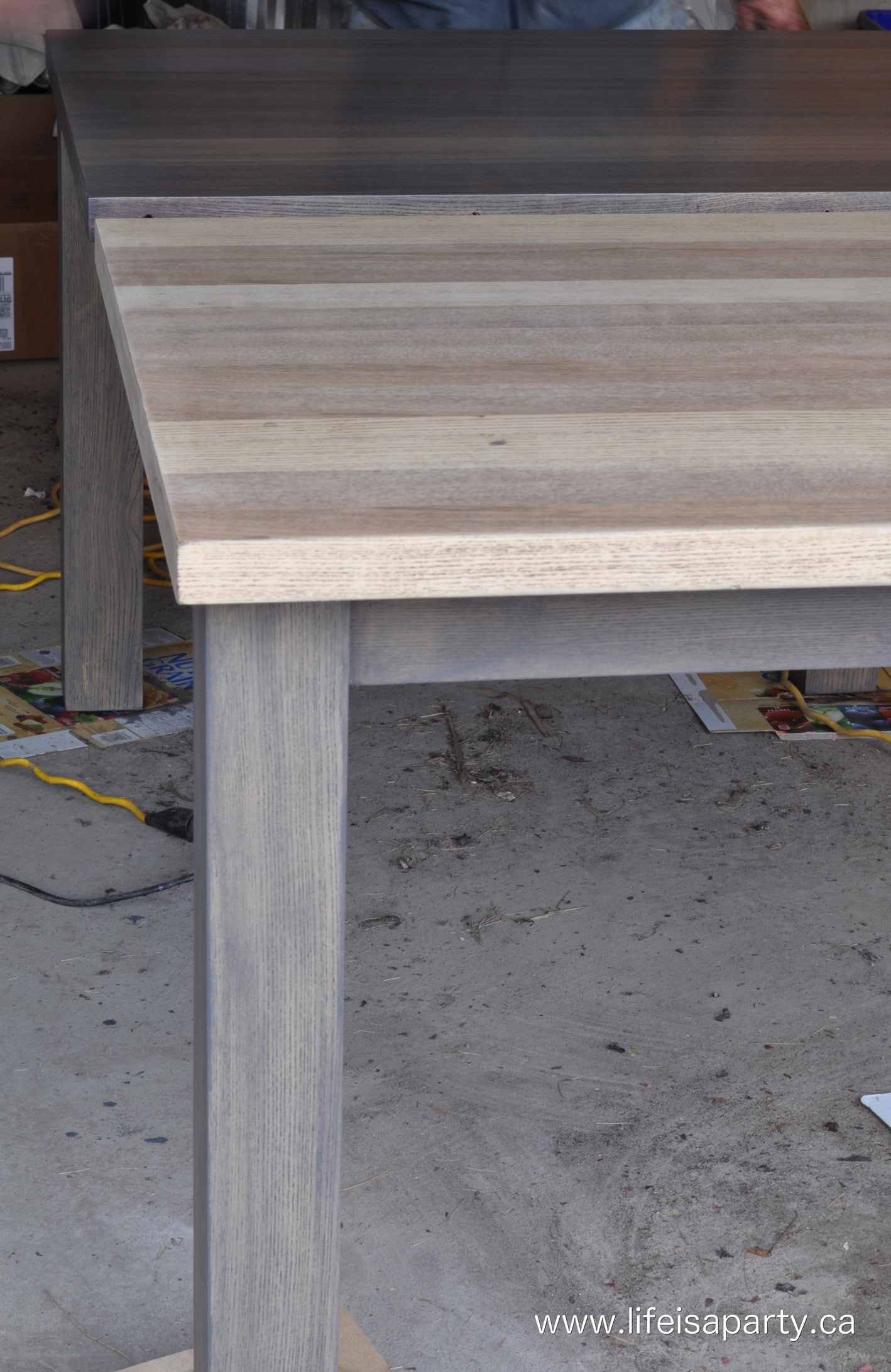 dark wood veneer dining table that's been stripped and restrained grey