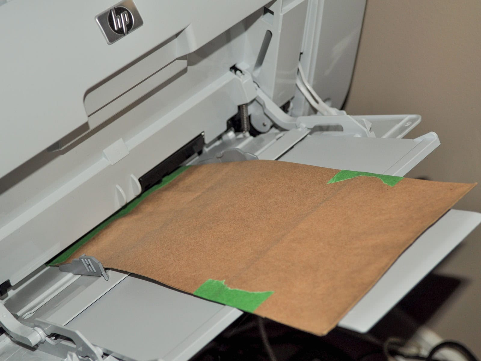 Kraft paper bag taped and fed through a printer to print a scavenger hunt list.