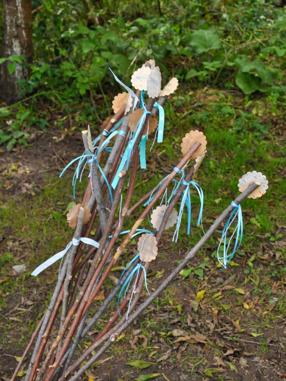 Bundle of custom birch bark labeled roasting sticks tied with aqua ribbon.