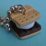 DIY s'more charm made from polymer clay at a camping themed birthday party.