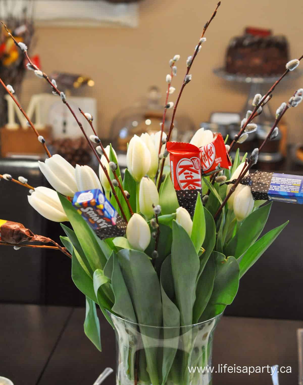 White tulips with mini chocolate bars for a chocolate themed party.