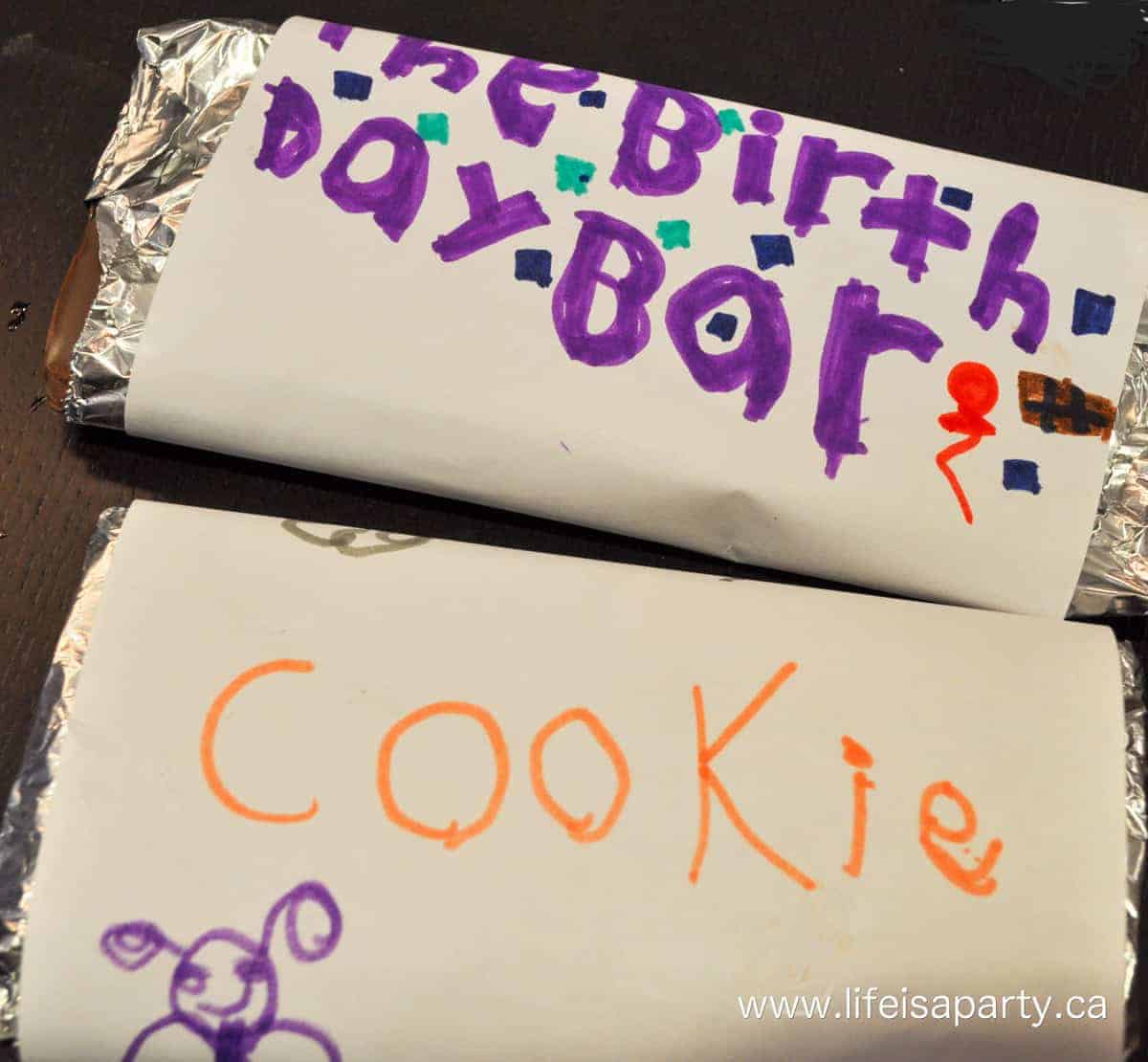 Homemade chocolate bars at make your own chocolate bar activity wrapped in foil with paper labels.