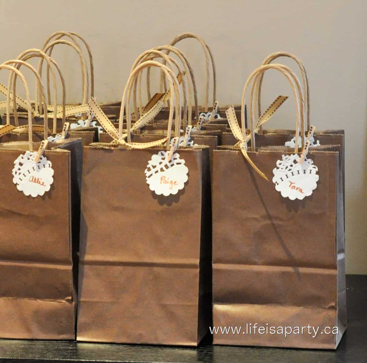 Chocolate party brown paper loot bags, with name labels and ribbons.