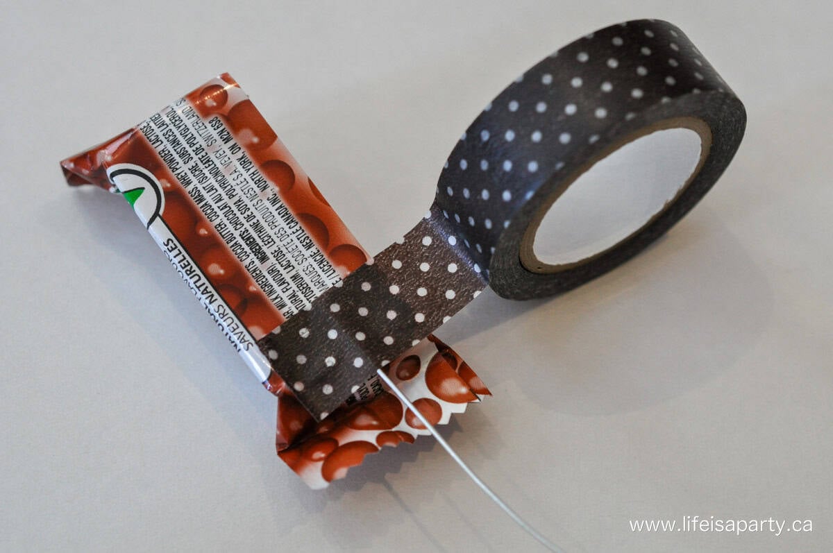 Making chocolate flowers with wire, mini chocolate bars, and brown washi tape.