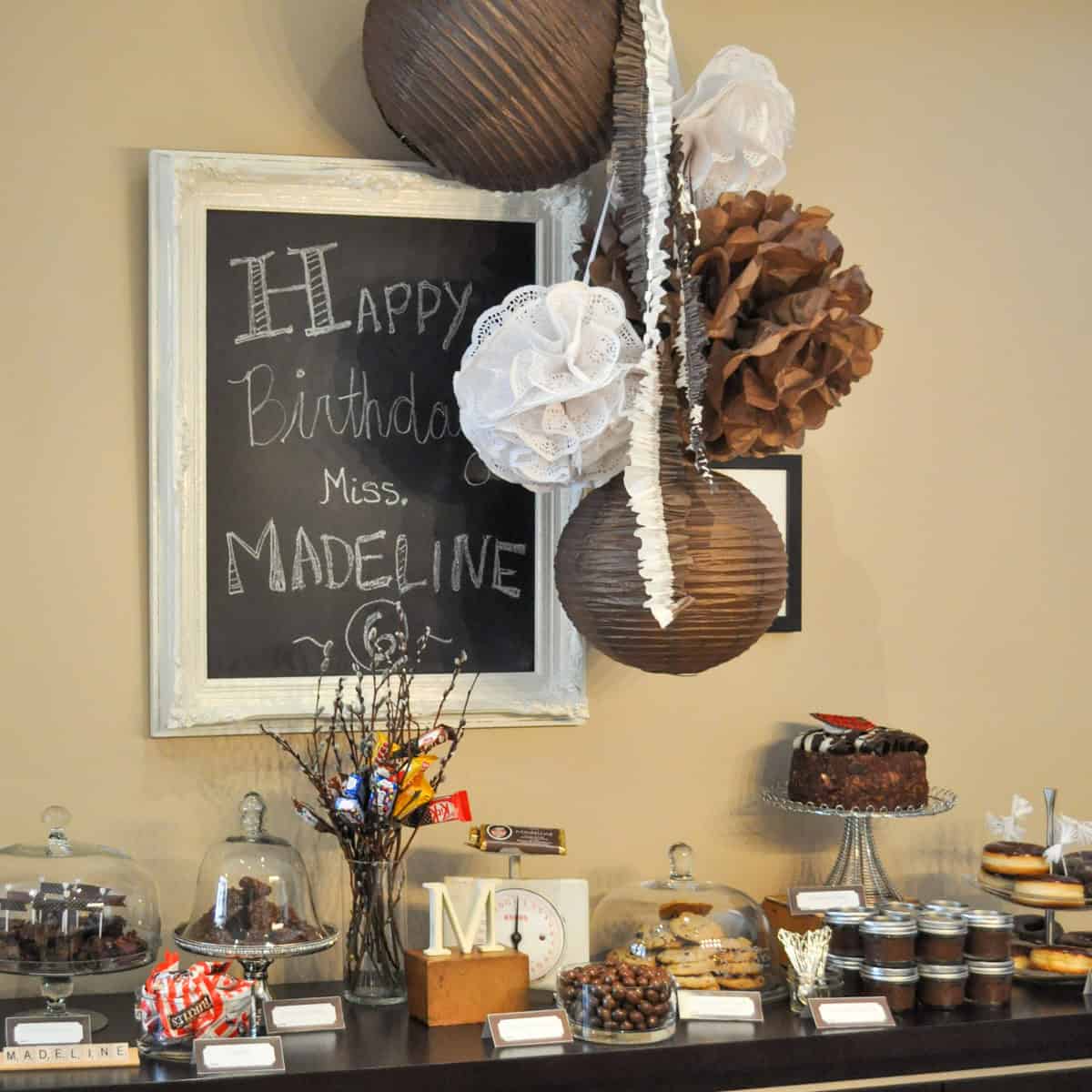 Chocolate themed dessert table with brown decor and chocolate treats.