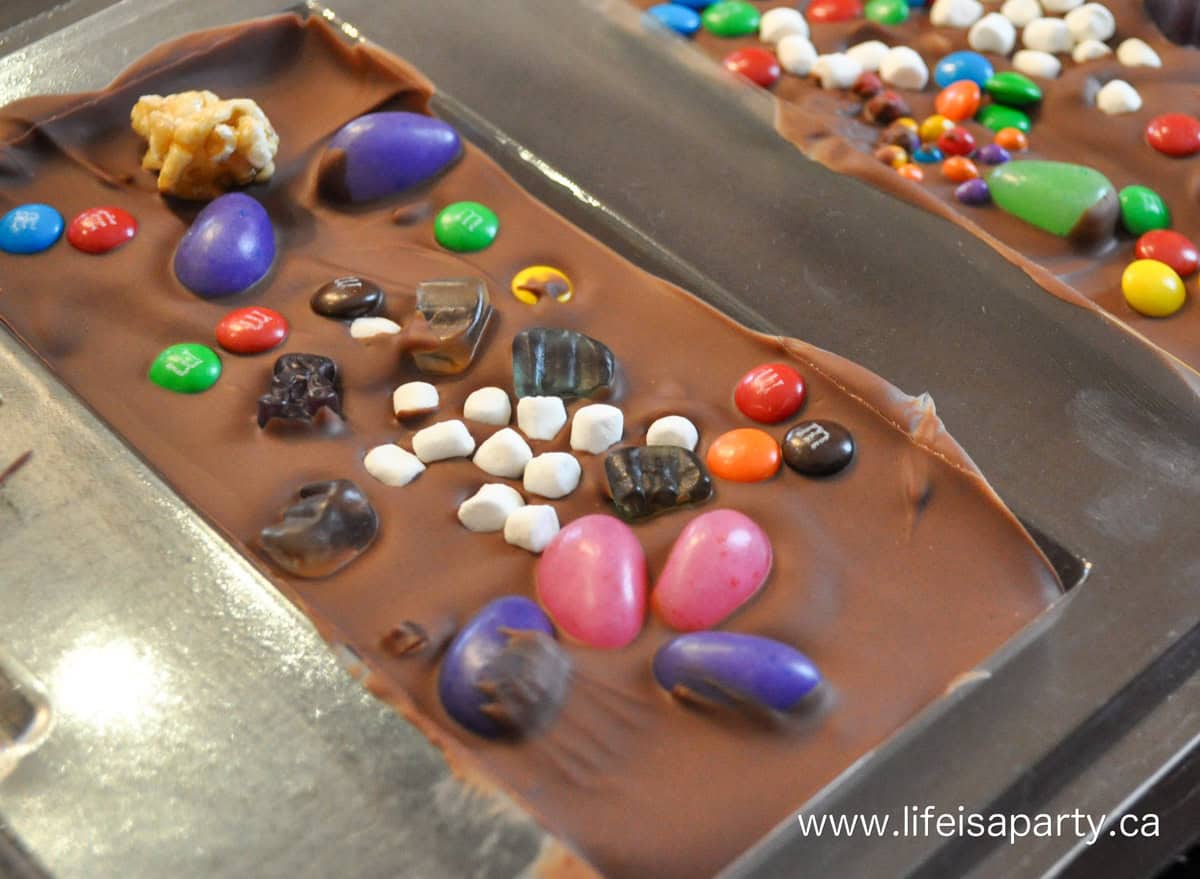 Make your own chocolate bar activity at a chocolate party with chocolate and candy in mold.