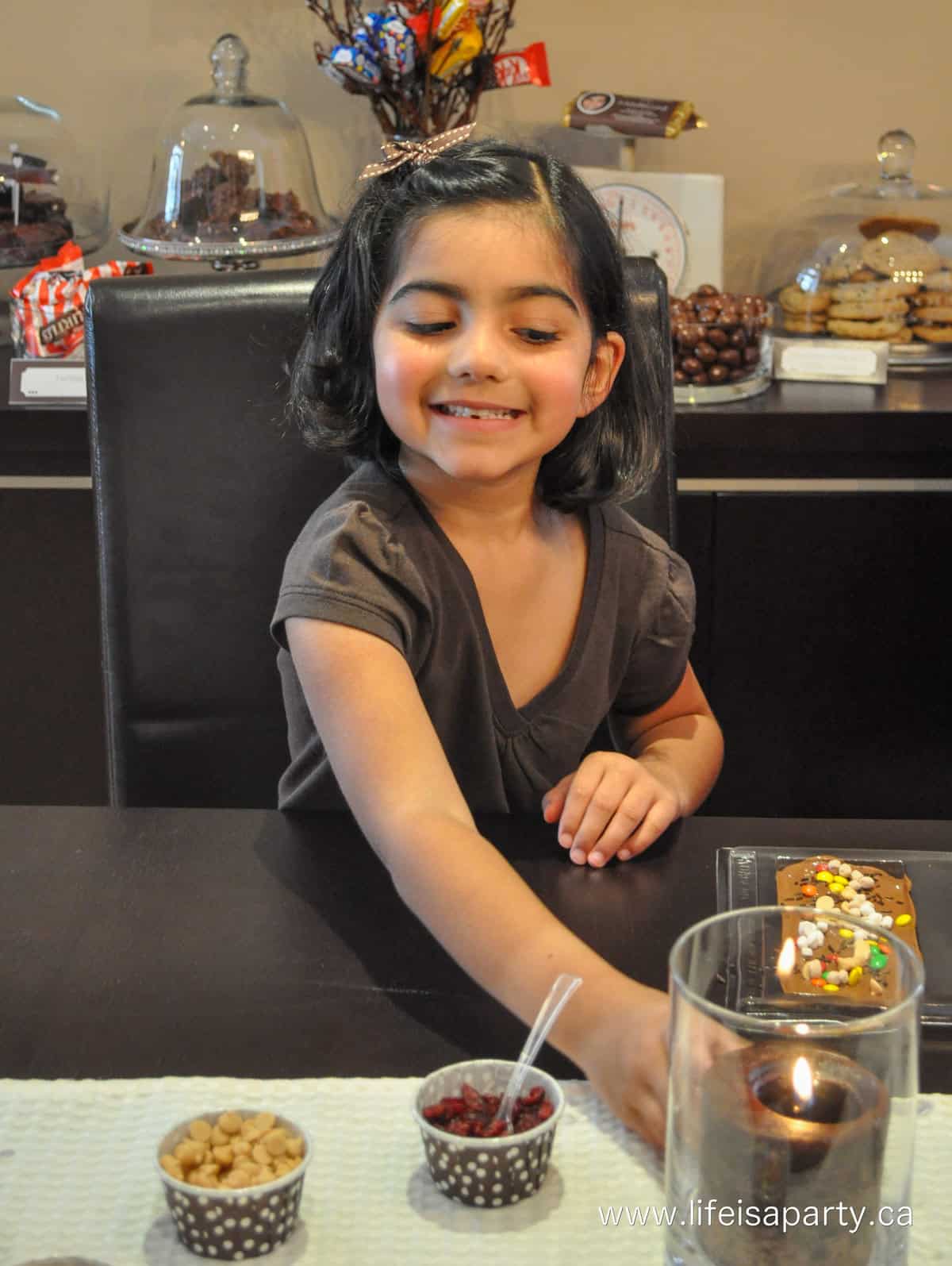 Child making their own chocolate bar in candy mold at chocolate themed party.