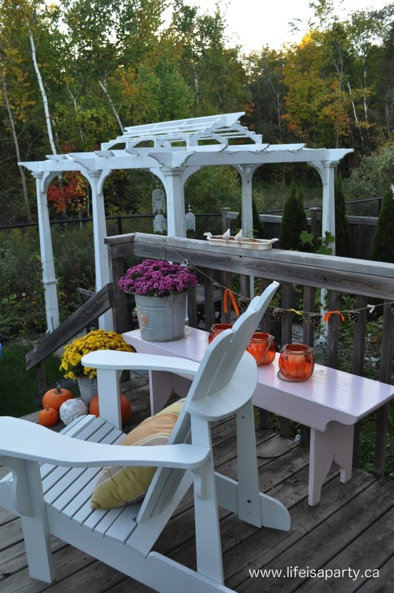 Fall Outdoor Decor Ideas -the back deck is styled for fall with pumpkins, mums, straw bales, pinecones, lanterns for a cozy fall.