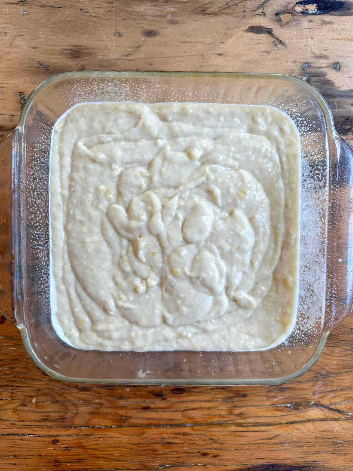 Banana snack cake batter in a 8 x 8 glass baking dish.