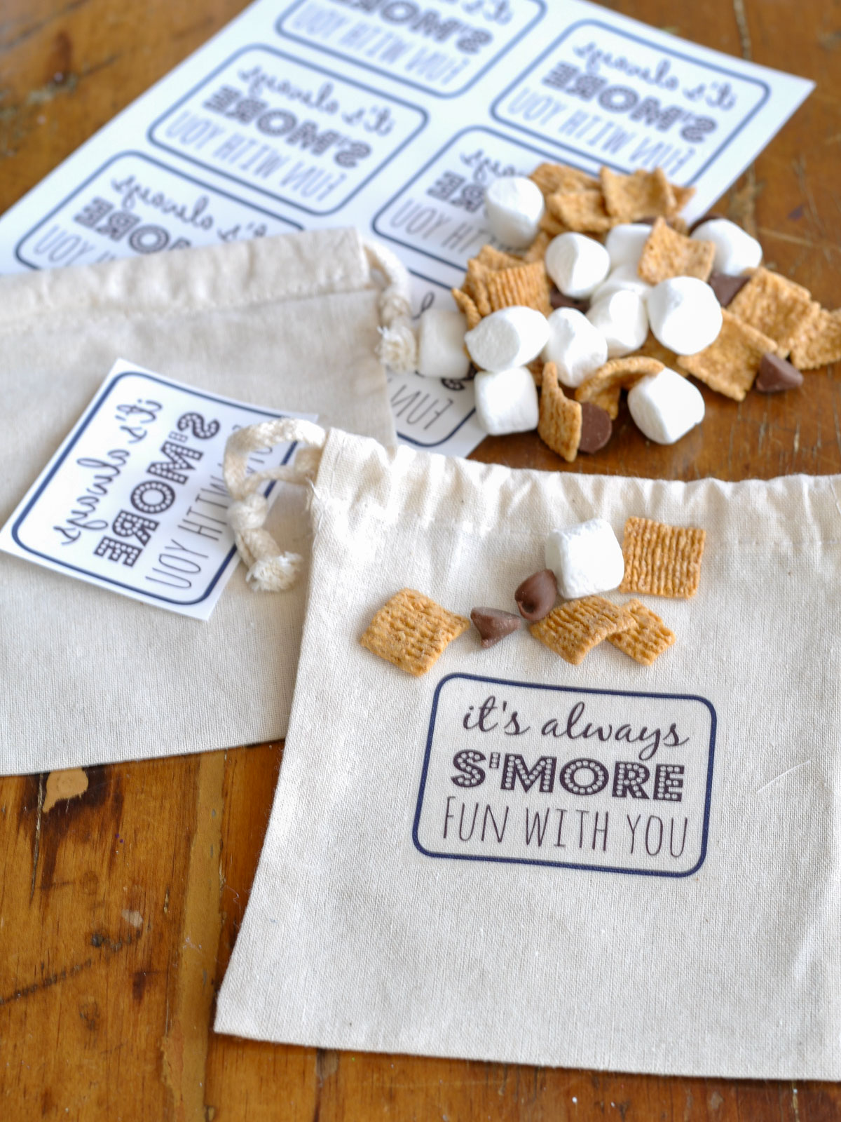 Free printable s'mores gift tag sheet next to filled canvas treat bags.
