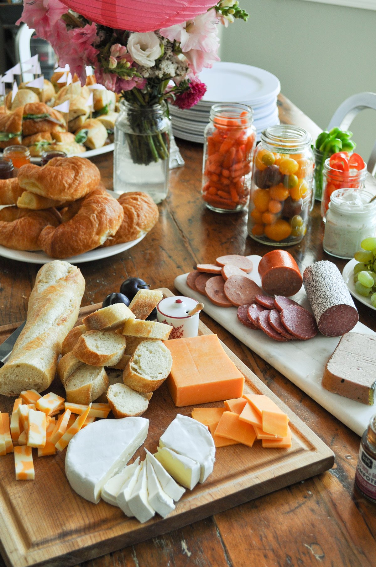 French inspired lunch with cheese, crackers, charcuterie, and sandwiches.