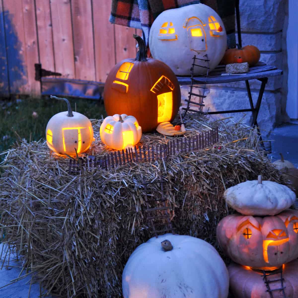 DIY Fairy pumpkin house village lit up with candles at night.