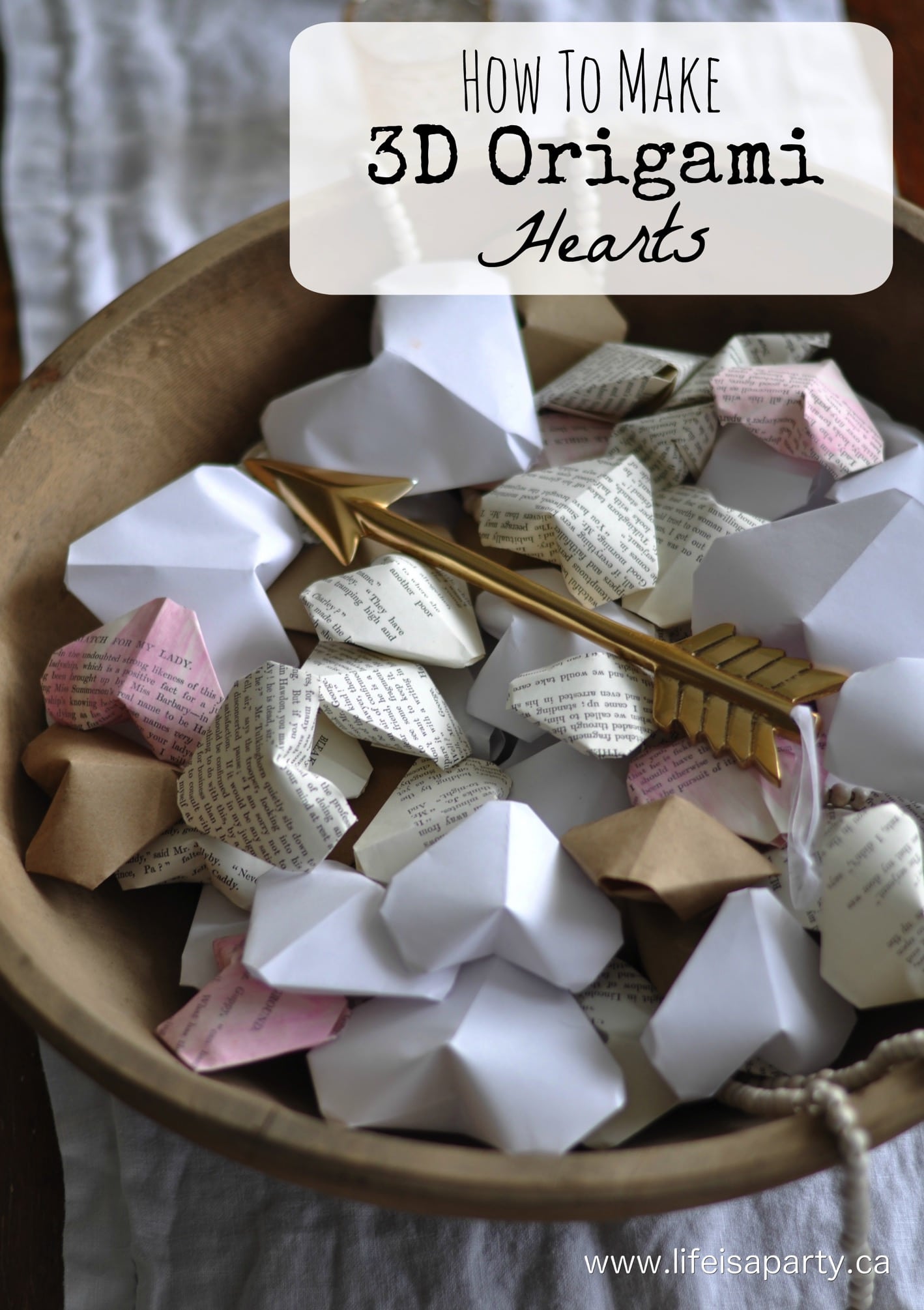 A wooden bowl full of paper 3d origami hearts made out of white, brown and book page paper.