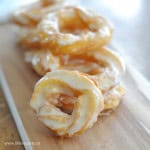 Homemade honey cruller donuts on a serving board.