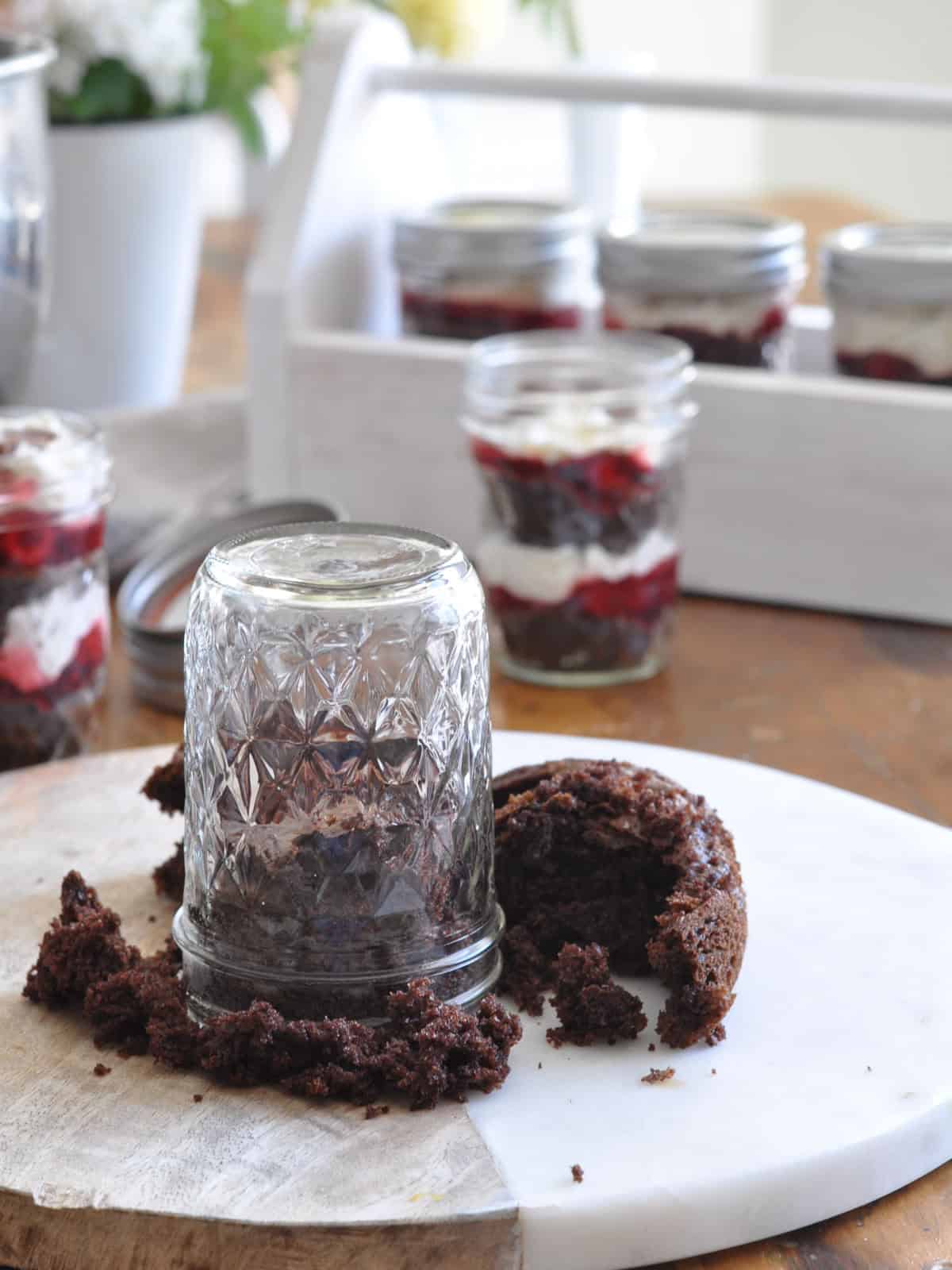 Mason jar pressed into chocolate cake as a cookie cutter to cut circles for individual black forest trifle layers.