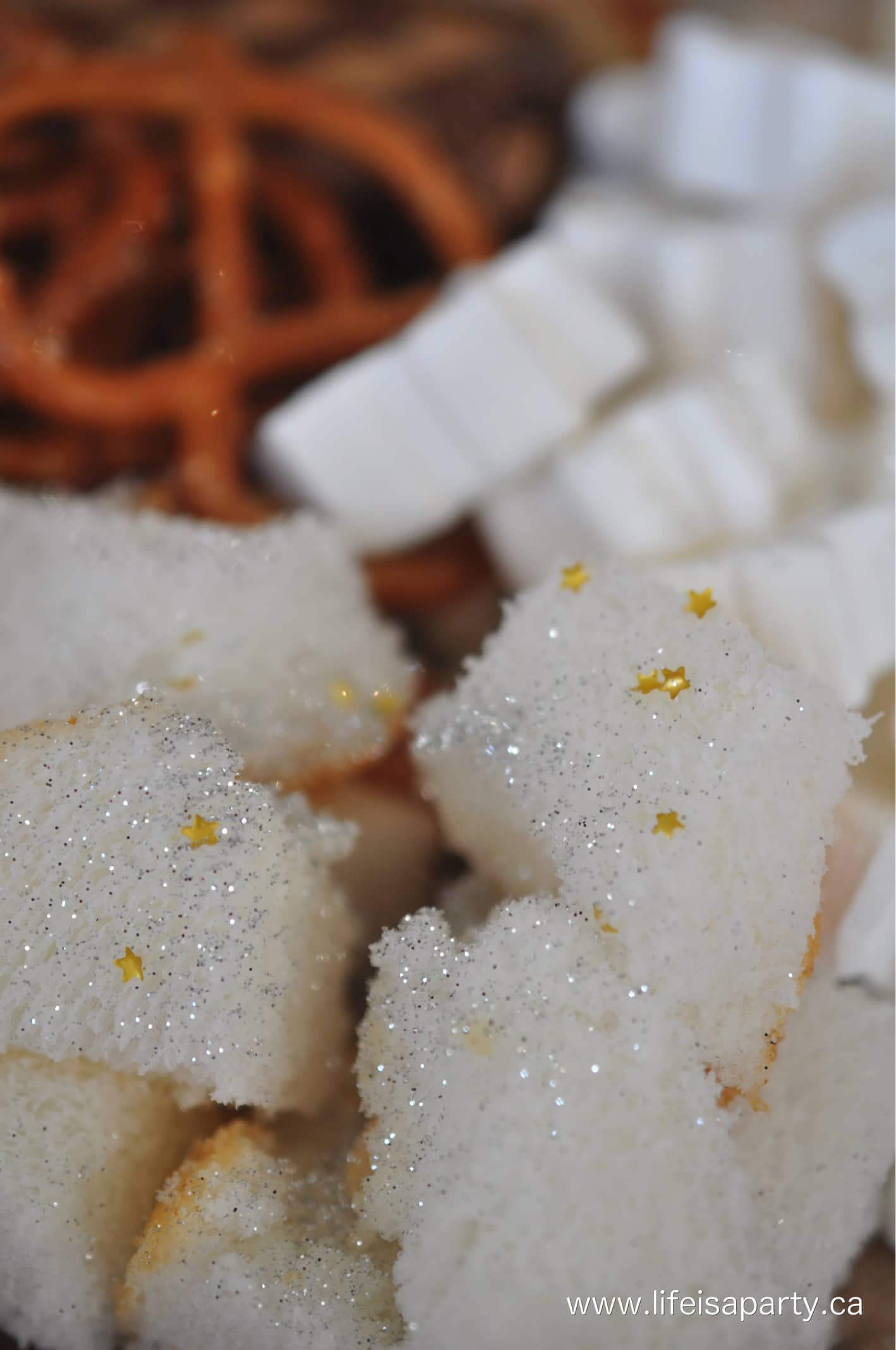 Angel food cake with edible glitter and star sprinkles on it.