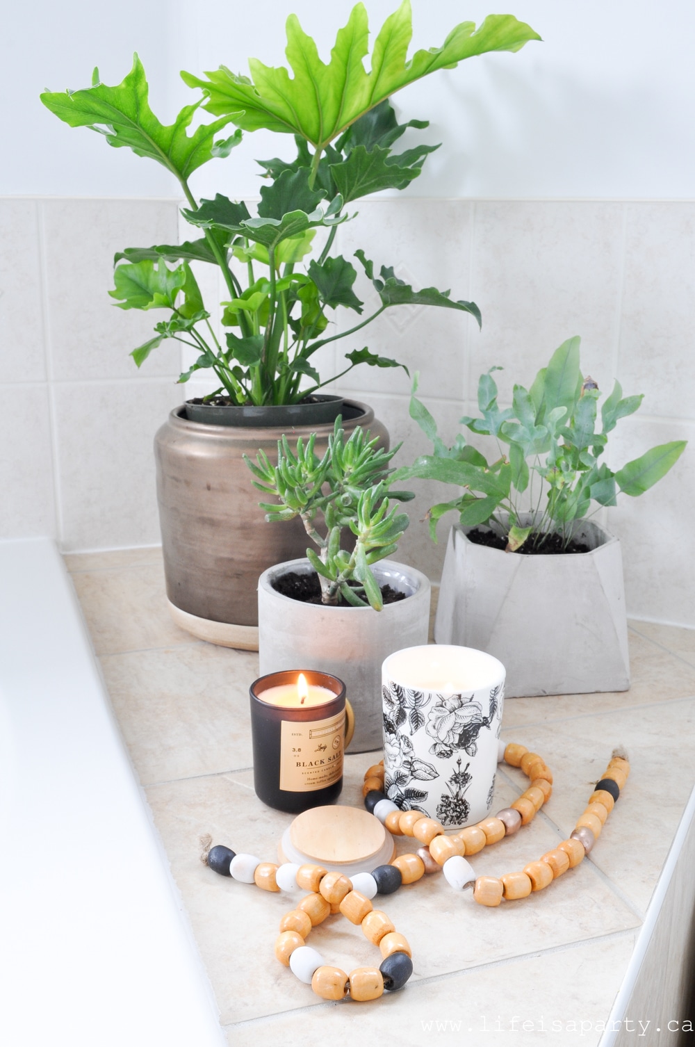 Modern Boho Bathroom Refresh -fresh white paint, a DIY tub tray, beads, candles, and lots and lots of plants turned this bathroom from boring to boho in just a few days.