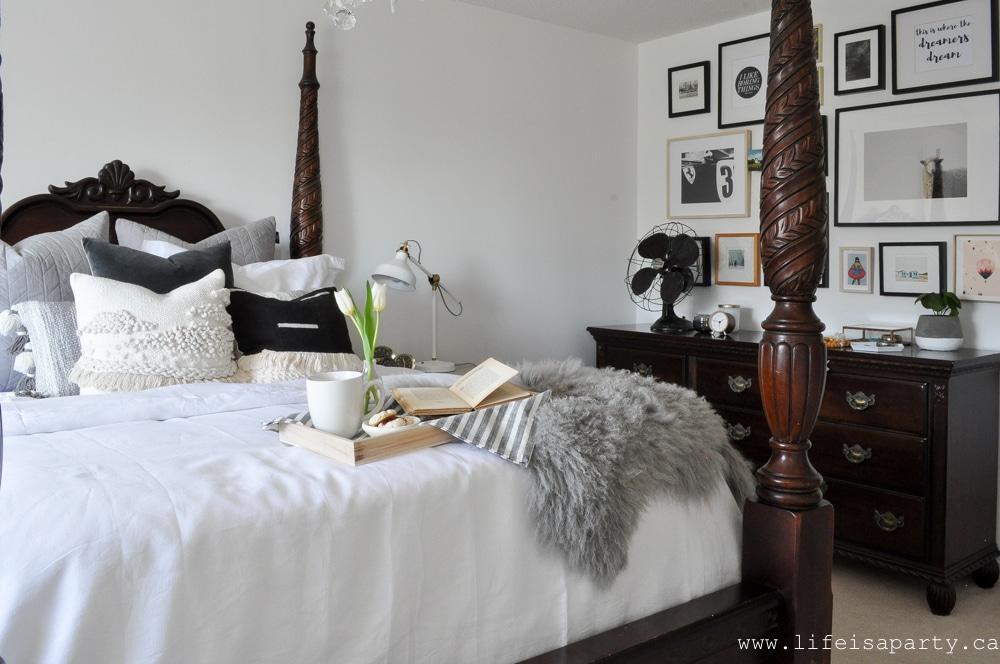 Modern Boho Bedroom: Black and white, woven wall hangings, a modern gallery wall, lots of plants, boho string lights, and tons of textured pillows give this room its European Modern Bohemian vibe.