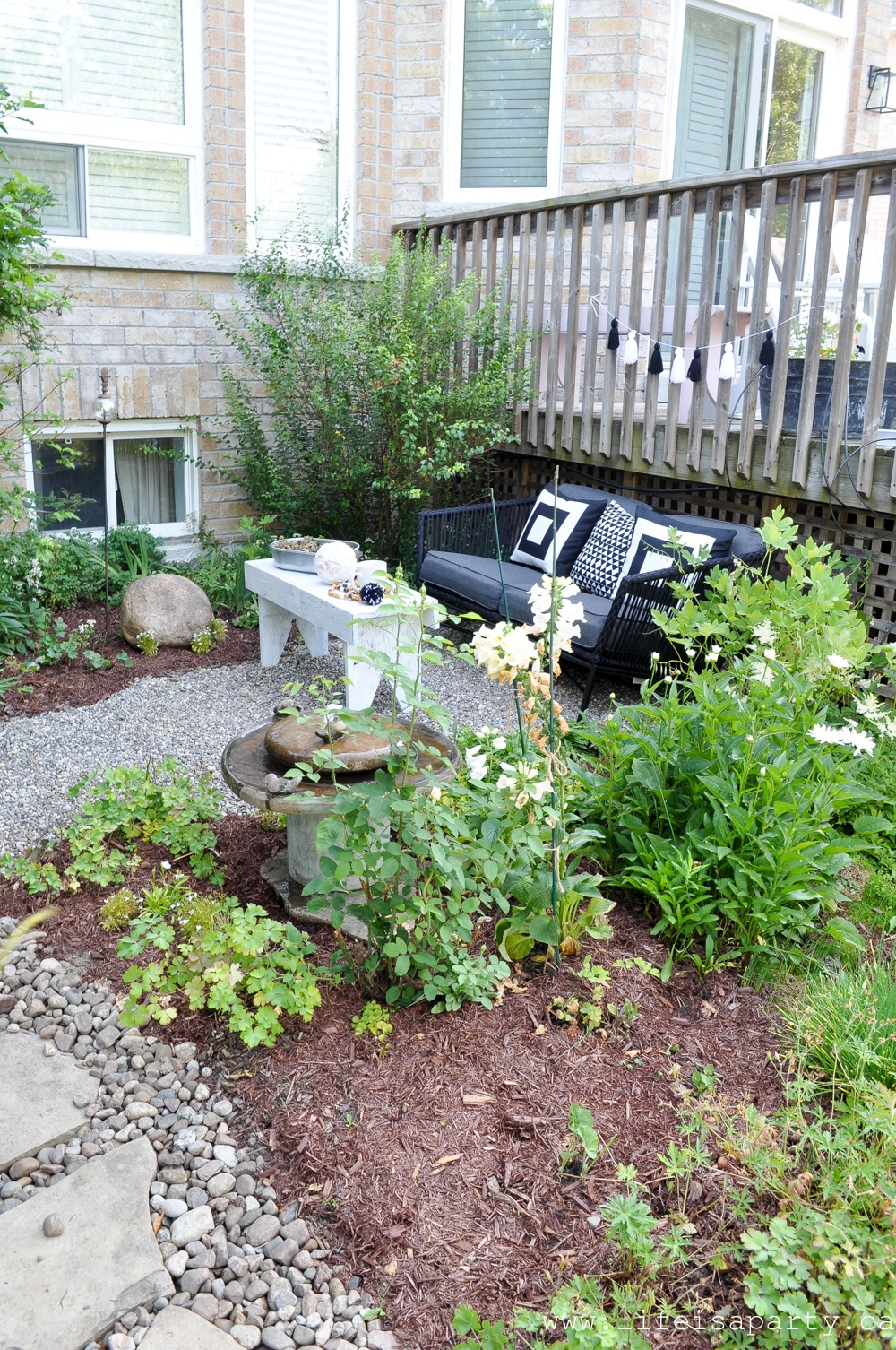 pea gravel seating area in a small black and white garden