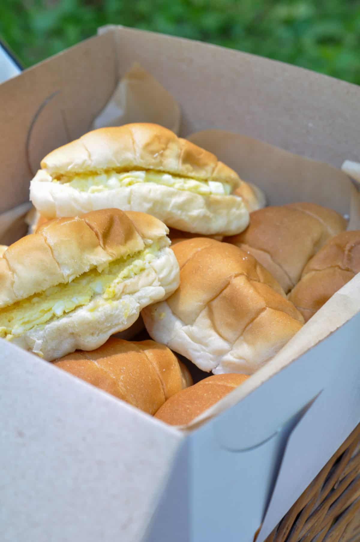 Egg salad sandwiches on mini croissants for a tea party picnic.