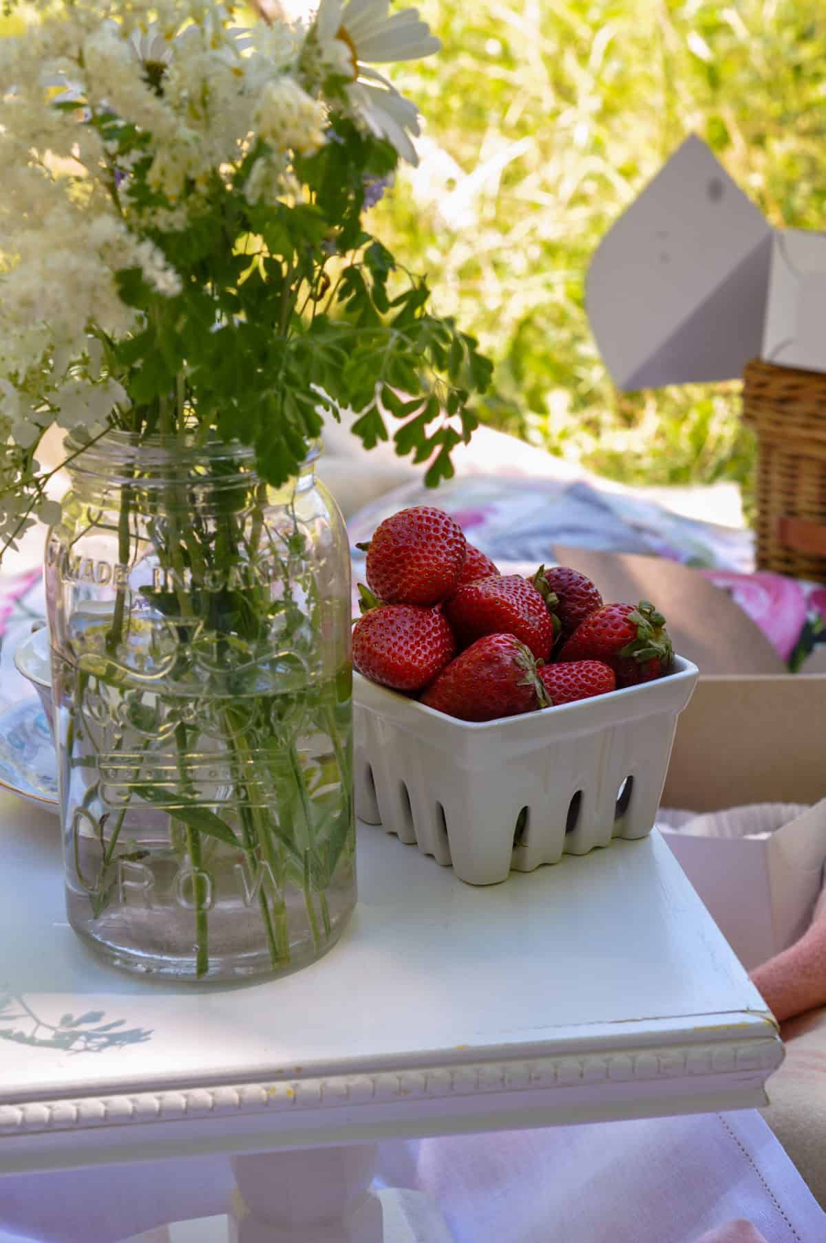 Wildflowers and fresh strawberries styled for a tea party picnic.