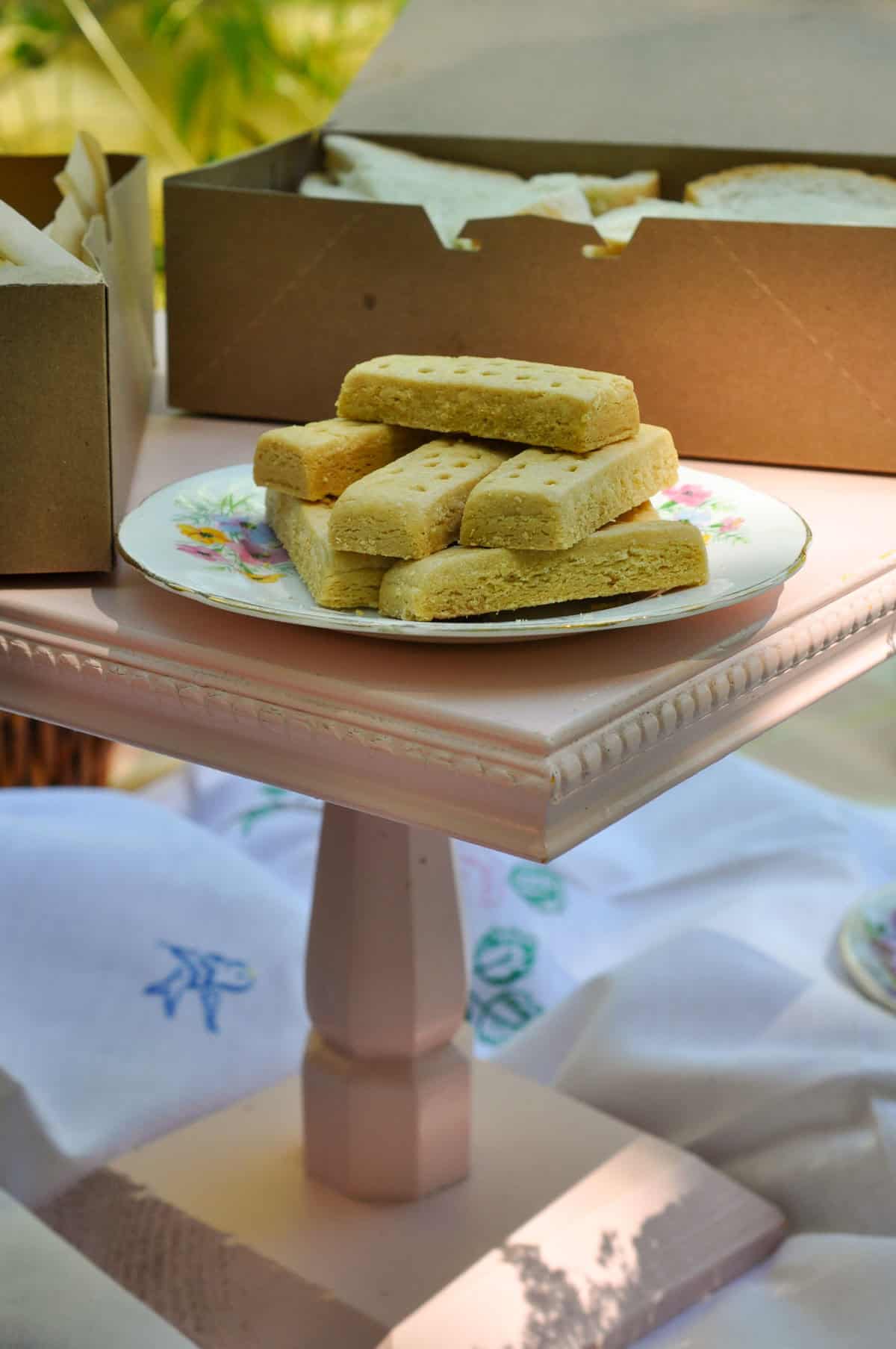 Stack of shortbread cookies on a floral plate for a tea party picnic.