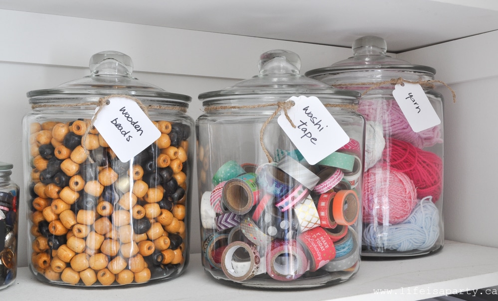 organizing craft supplies in glass canisters
