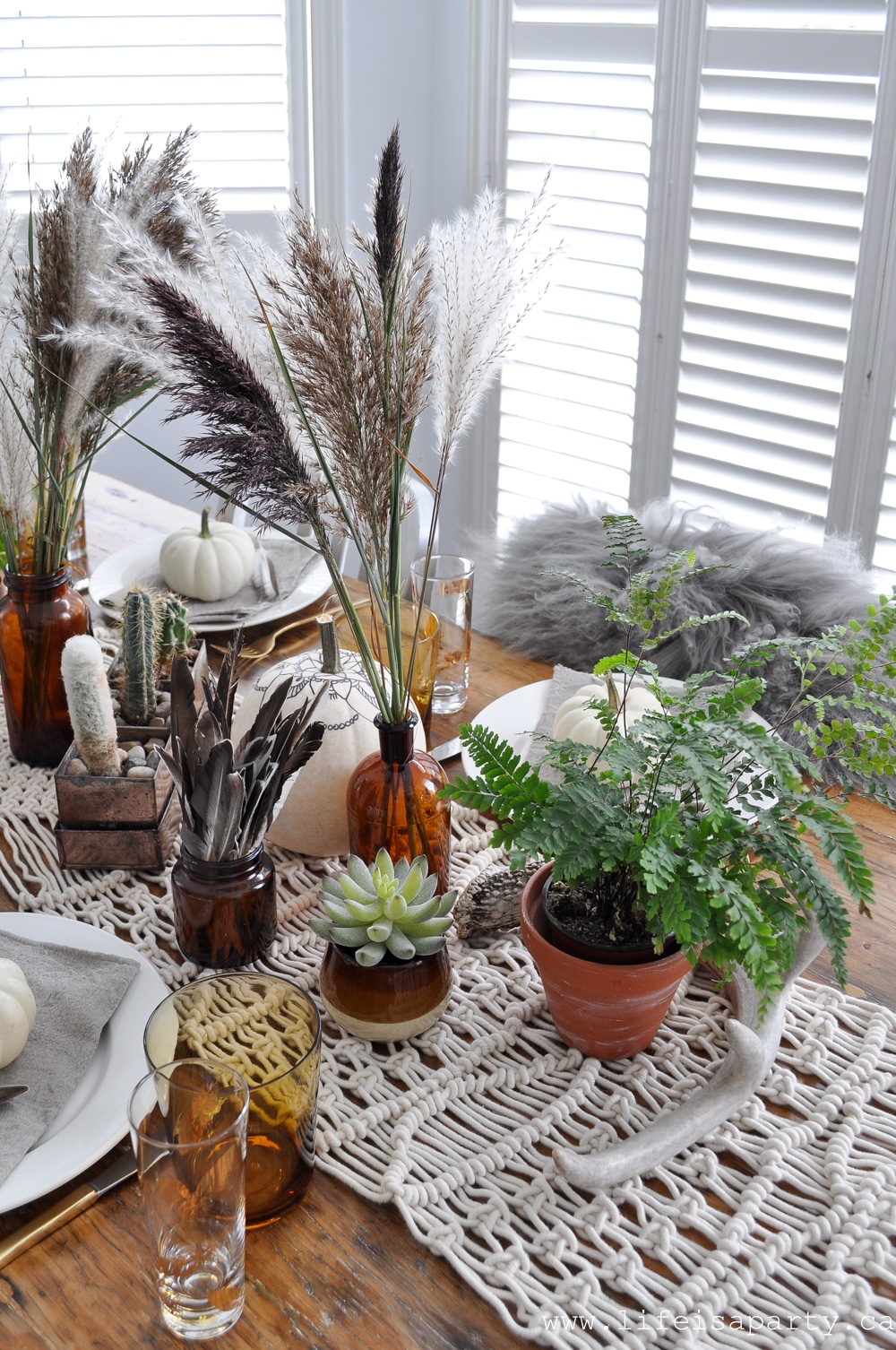 Boho Thanksgiving Table with macrame, feathers, plants, and pampas grass