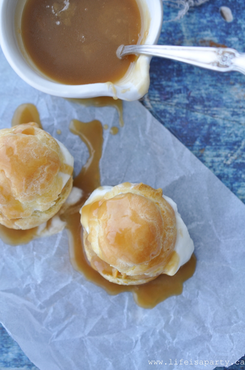 Pumpkin Cream Puffs: A cream puff filled with pumpkin pastry cream, whipped cream, and topped with warm caramel sauce for the perfect fall dessert.