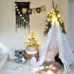 Christmas reading tent made with birch poles and vintage lace tablecloths.