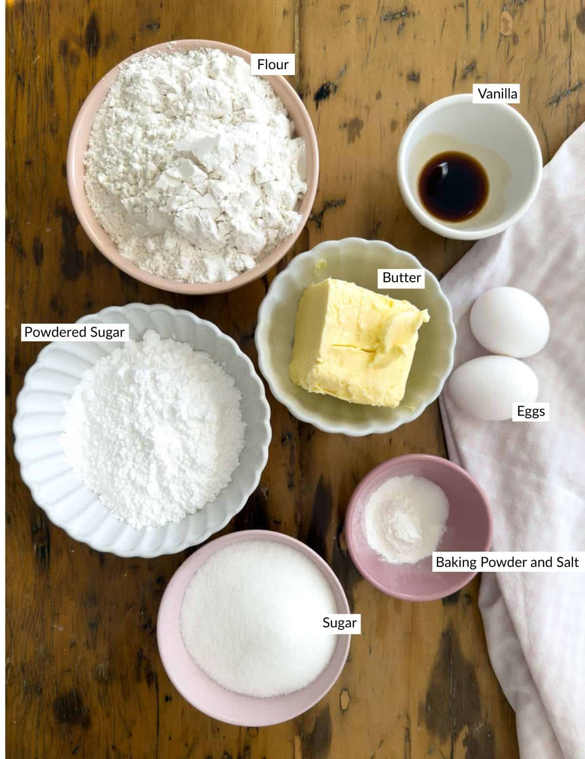 Ingredients for cut out butter cookies including flour butter sugar eggs and vanilla.