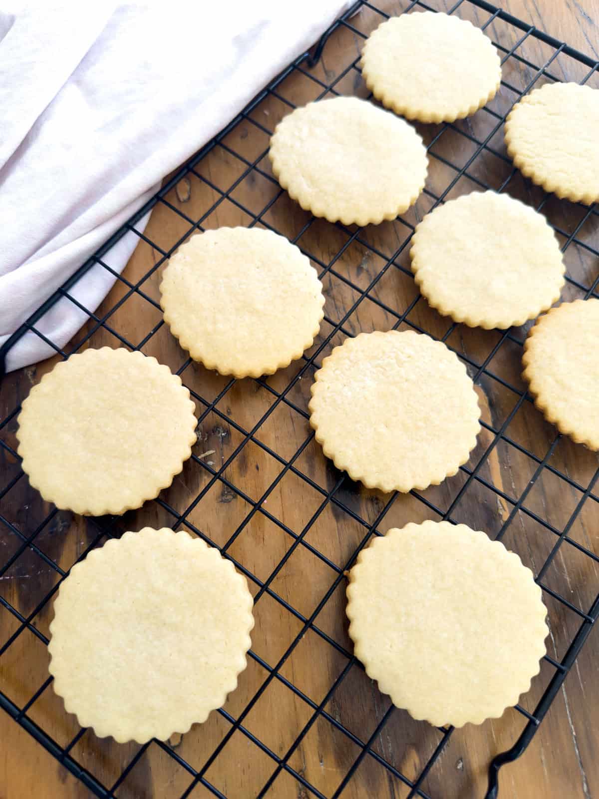Baked cut out butter cookies cooling on wire rack overhead.