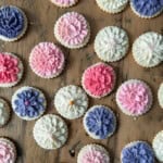 Cut out butter cookies decorated with pink purple and cream flower buttercream.