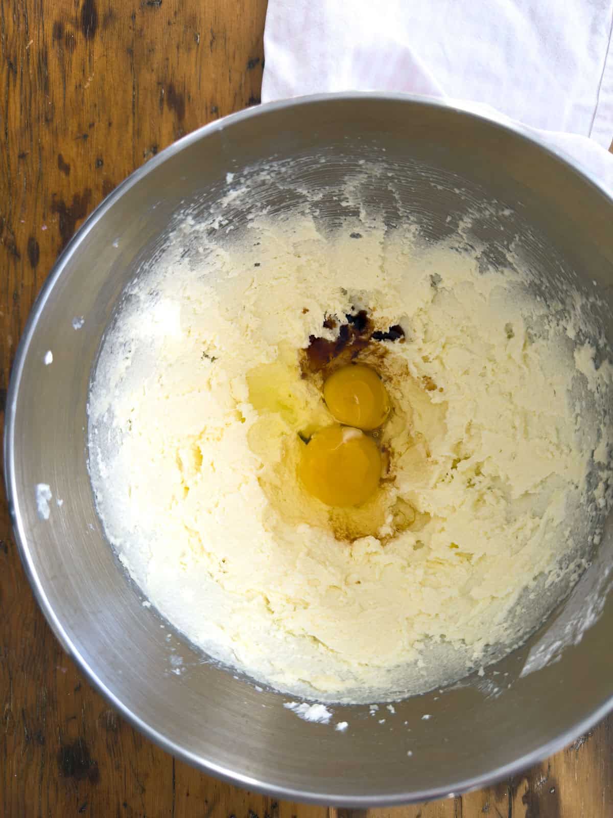 Eggs and vanilla added to creamed butter and sugar in stand mixer bowl