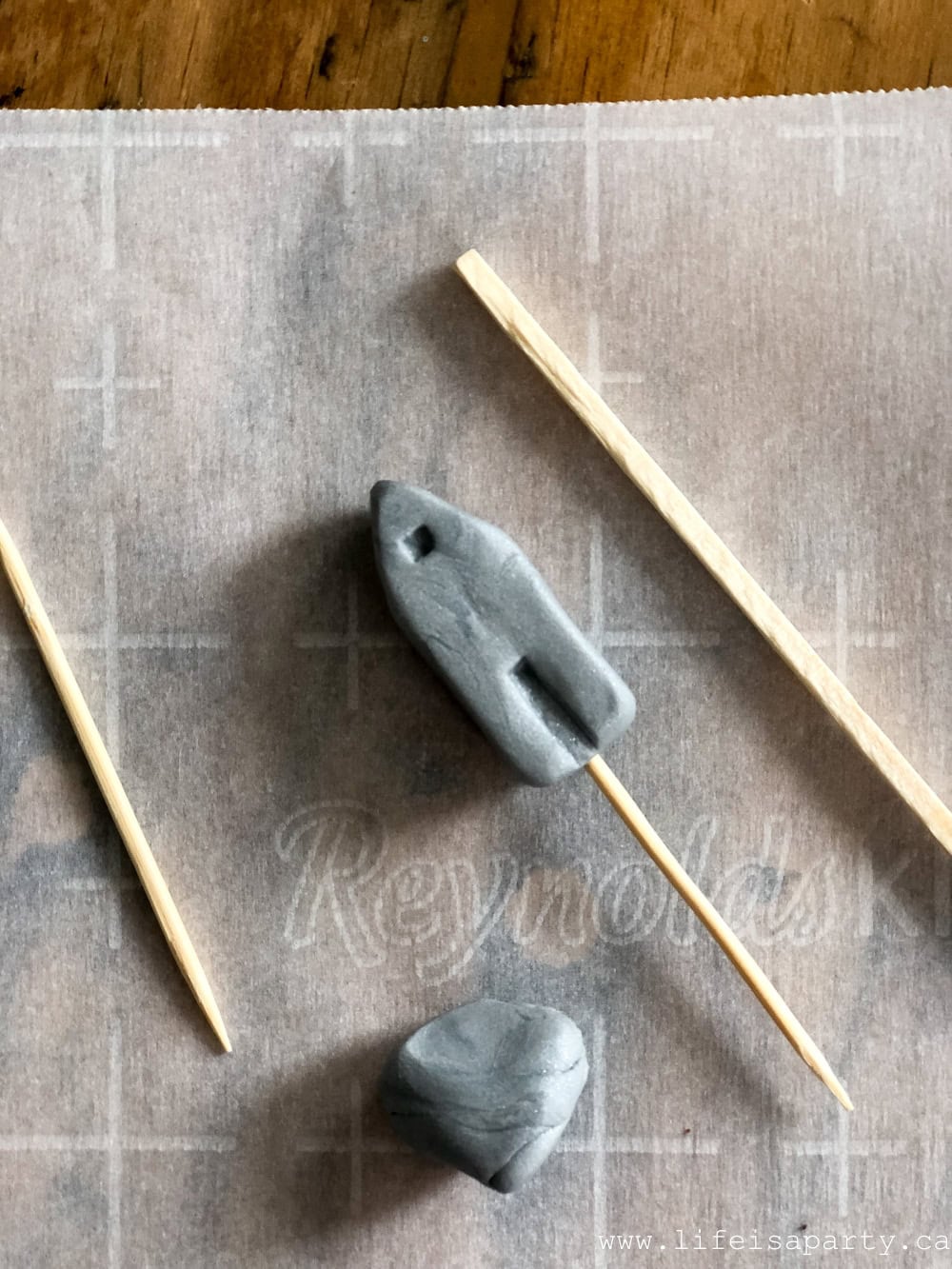 How to make a tiny polymer clay house using a match stick to create a door and the end of a lollipop stick to make a round window.