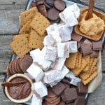 S’mores charcuterie board with graham crackers, marshmallows and chocolate for summer entertaining.