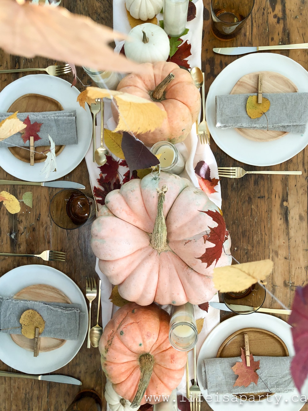Thanksgiving table with pink pumpkins and fall leaves