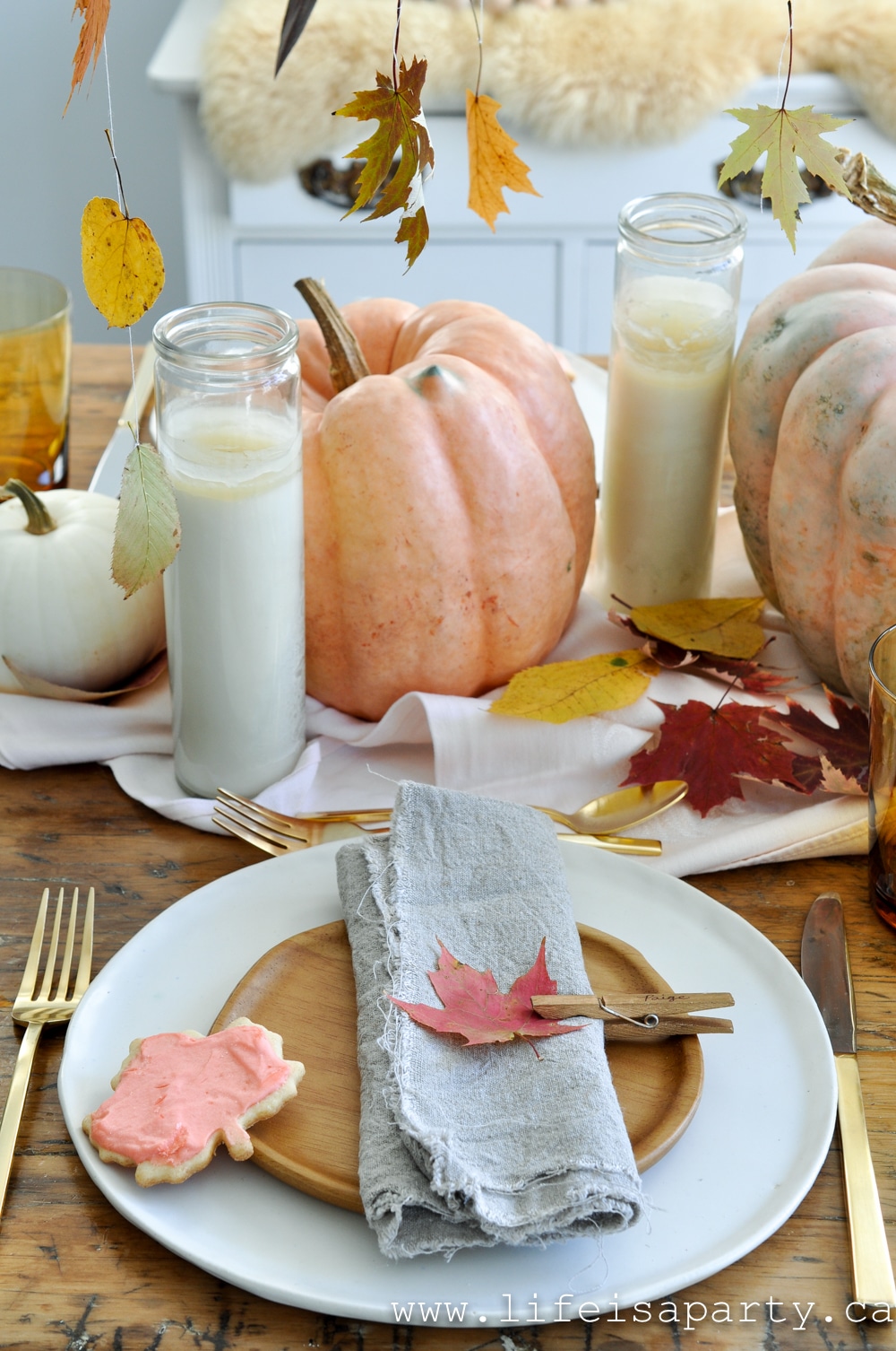 Fall Leaf Thanksgiving Table: Hanging pressed fall leaves, and pink heirloom pumpkins, ombre leaf cookies, and cloths pin place cards make a beautiful table.