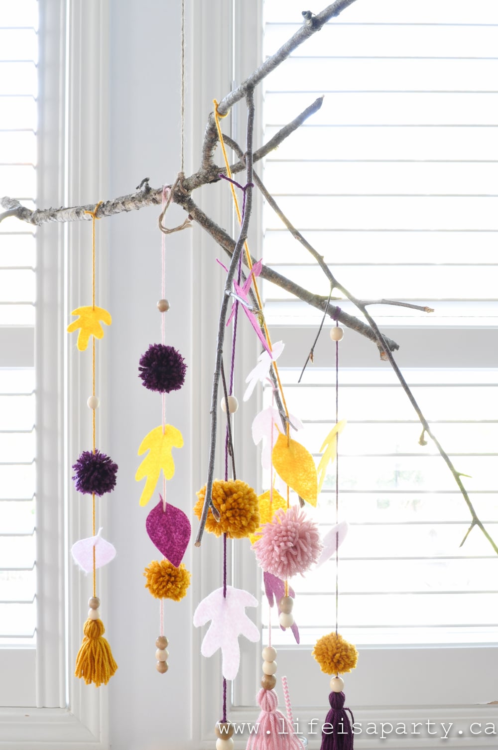 Branch mobile with felt leaves, pom poms, tassels, and wood beads