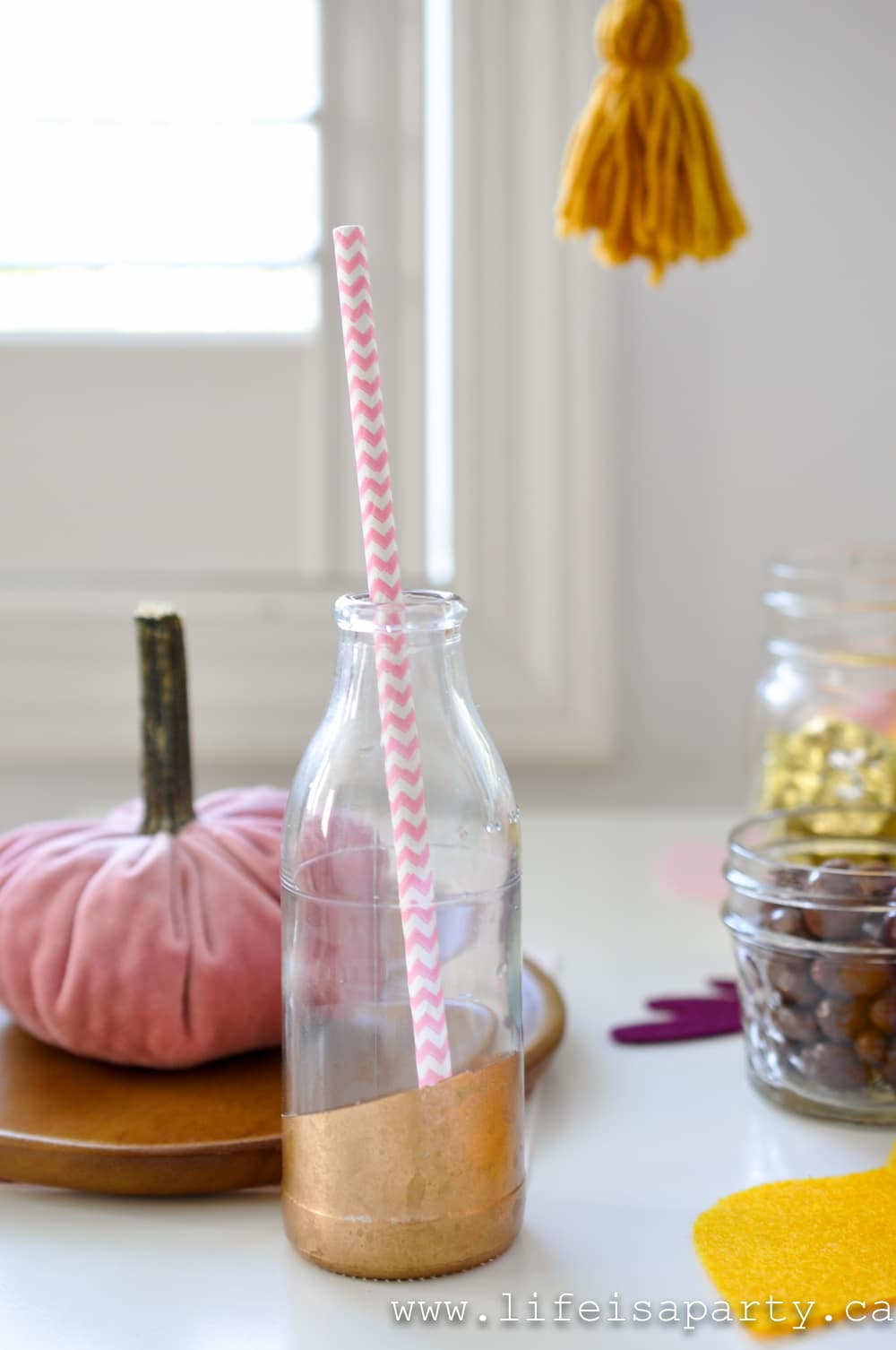 glass bottle with a pink paper straw
