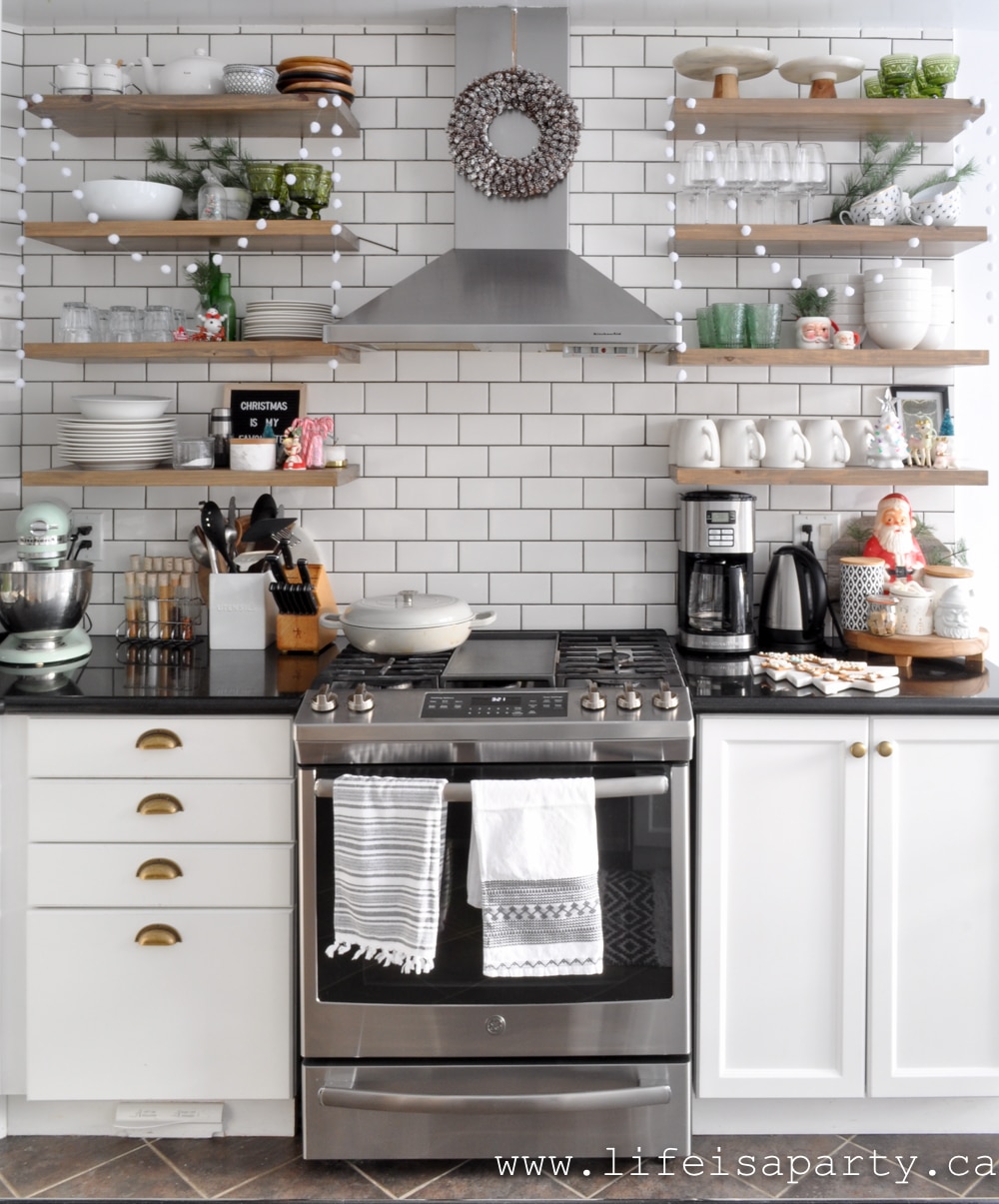 Open kitchen shelves decorated for Christmas with green decor