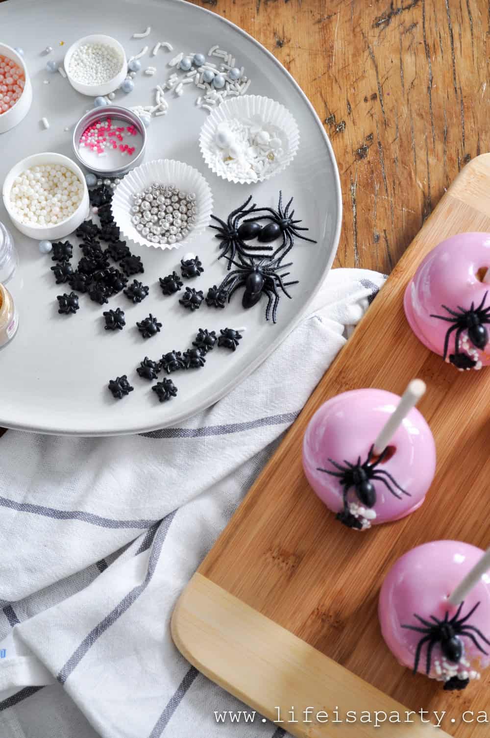 Plate of sprinkles and decorations for pink candy apples.