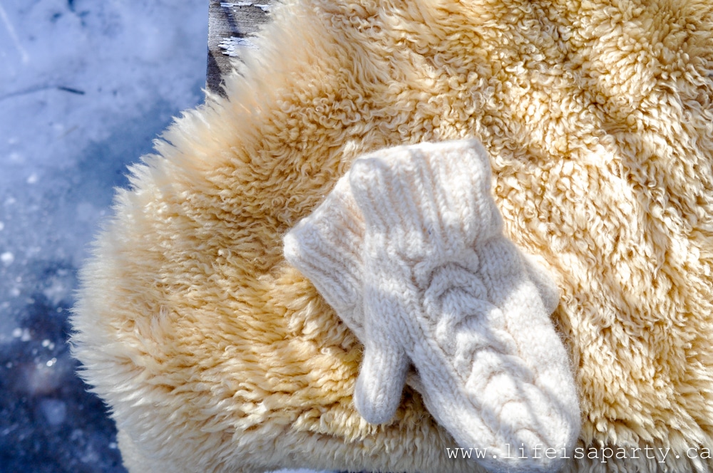 wool mittens on a sheepskin rug