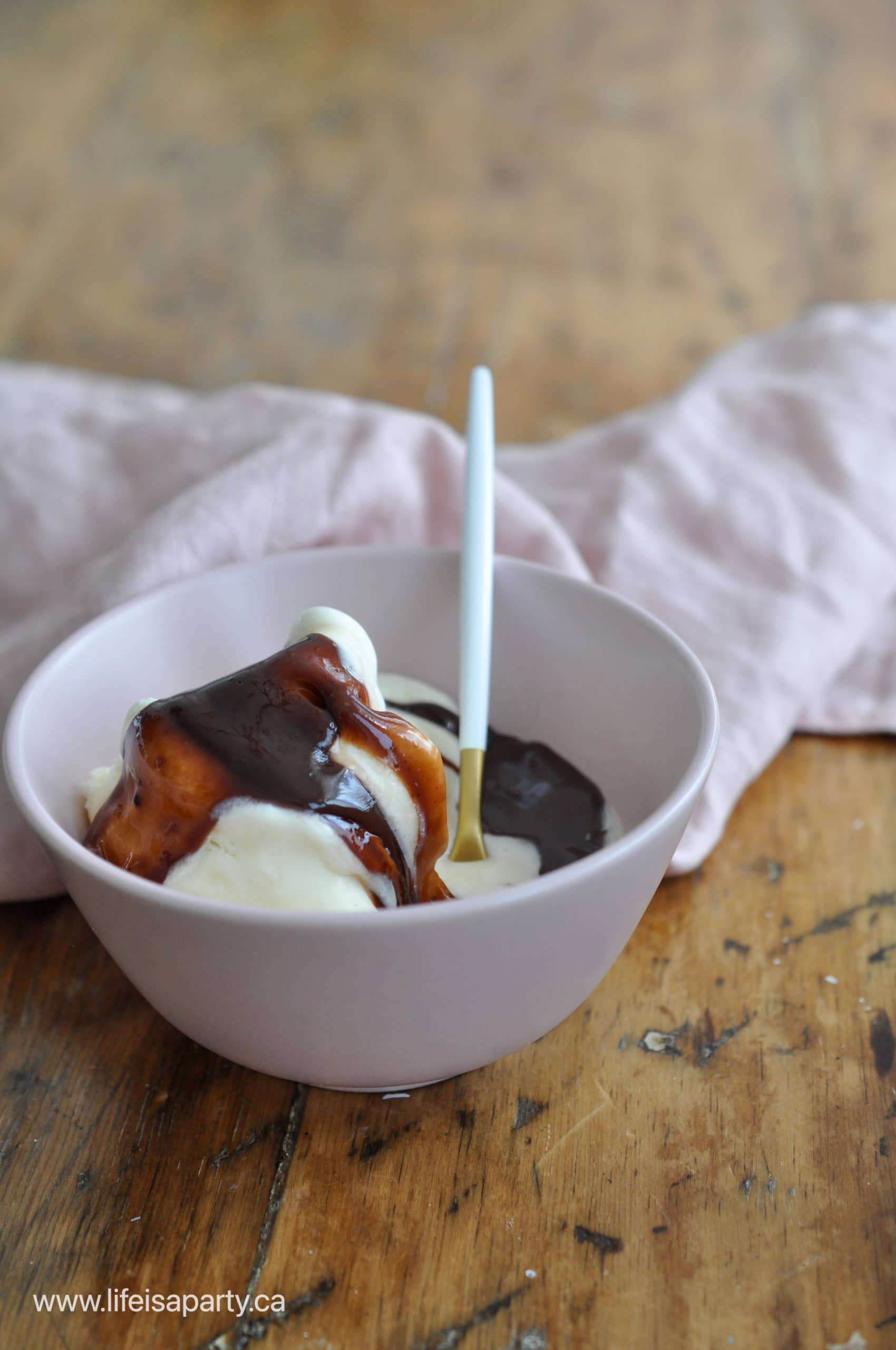 Bowl of vanilla ice cream topped with thick homemade hot fudge sauce.