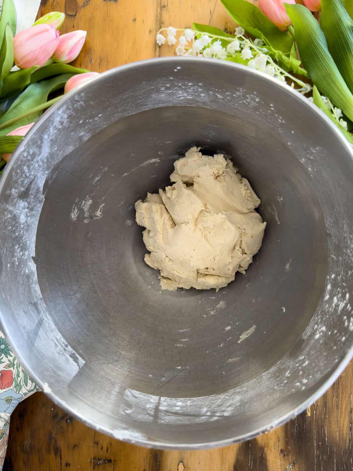 Vanilla shortbread cookie dough with vanilla bean paste mixed in, in a stand mixer bowl.